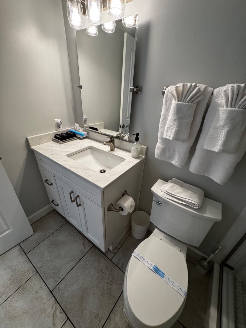 Fan-folded towels and sanitized toilet seal — MOR Clean Airbnb turnover signature finish