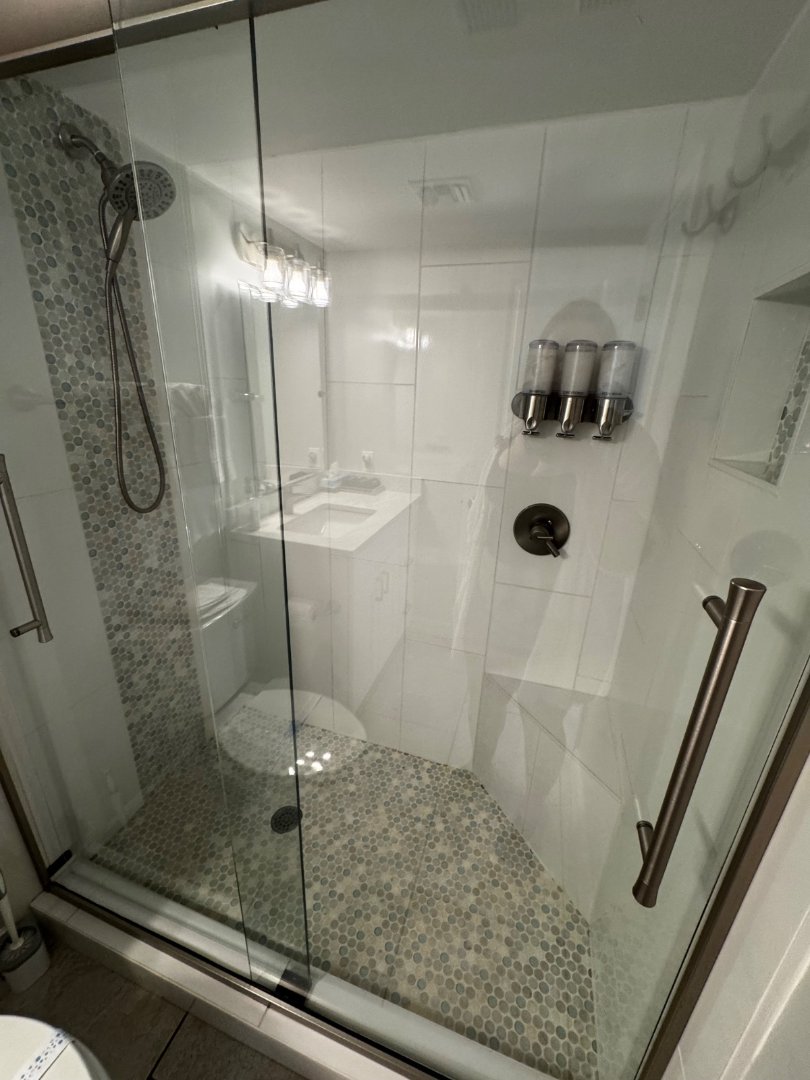 Streak-free glass shower with pebble tile floor scrubbed by MOR Clean