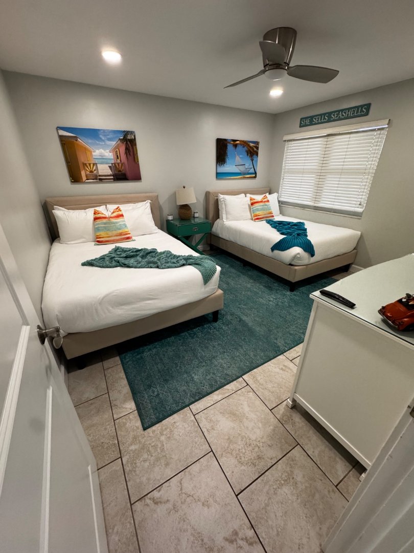 Beach-themed guest bedroom with crisp white linens after MOR Clean turnover
